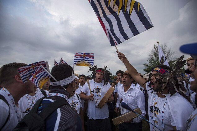 Athlètes des Jeux autochtones jouant des percussions et agitant des drapeaux de la Colombie-Britannique. Athlètes des Jeux autochtones jouant des percussions et agitant des drapeaux de la Colombie-Britannique.