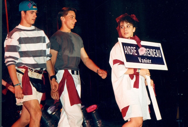 De gauche à droite, un jeune homme en pantalon court avec un chandail rayé horizontalement et une casquette de côté sur la tête. Puis au centre, un deuxième vêtu de pantalons blancs et gaminet gris. Et finalement à droite, une jeune femme toute de blanc vêtue avec une pancarte sur laquelle on peut lire ANDRÉ LAURENDEAU, Vanier. De gauche à droite, un jeune homme en pantalon court avec un chandail rayé horizontalement et une casquette de côté sur la tête. Puis au centre, un deuxième vêtu de pantalons blancs et gaminet gris. Et finalement à droite, une jeune femme toute de blanc vêtue avec une pancarte sur laquelle on peut lire ANDRÉ LAURENDEAU, Vanier.