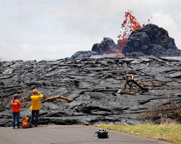 Des scientifiques de l'observatoire volcanologique d'Hawaï suivent l’évolution de la lave. Des scientifiques de l'observatoire volcanologique d'Hawaï suivent l’évolution de la lave.