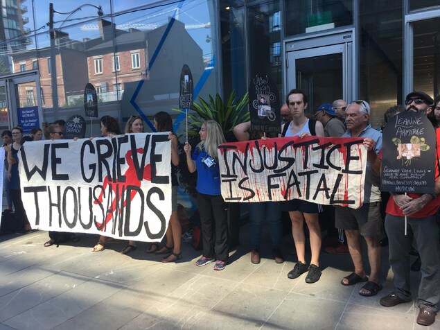 Une dizaine de personnes tiennent des pancartes. Une dizaine de personnes tiennent des pancartes.