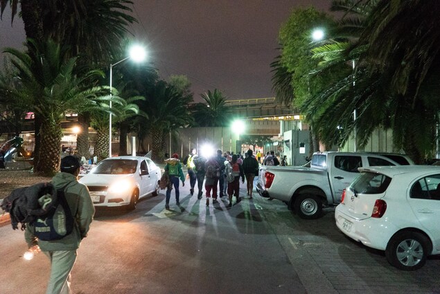 De dos, des migrants marchent. De dos, des migrants marchent.