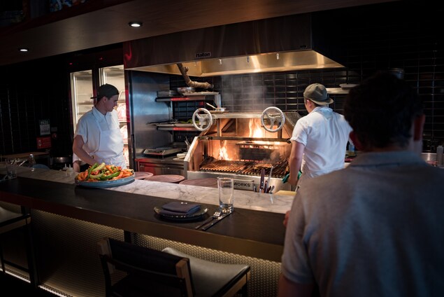 Un bar et trois chefs derrière le bar Un bar et trois chefs derrière le bar