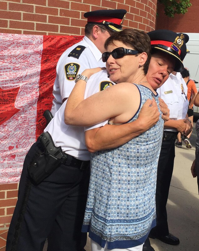 Une citoyenne enlace une policière devant le poste de police de Fredericton le 12 août 2018. Une citoyenne enlace une policière devant le poste de police de Fredericton le 12 août 2018.