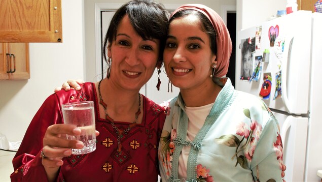 Les deux femmes posent pour la photo avec un verre d'eau à la main. Les deux femmes posent pour la photo avec un verre d'eau à la main.