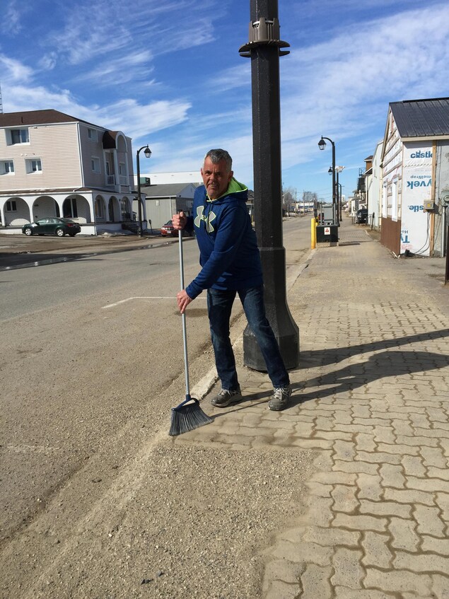 Un homme passe le balai dans une rue. Un homme passe le balai dans une rue.