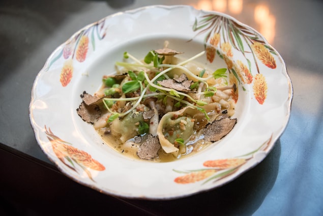 Un plat avec des truffes tranchées et des raviolis Un plat avec des truffes tranchées et des raviolis