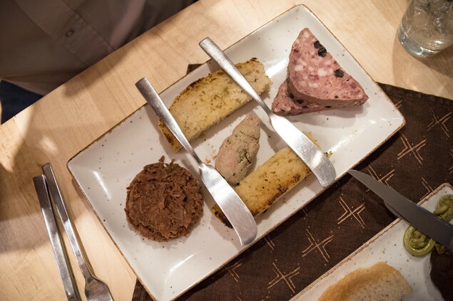 Un plat comprenant trois petites portions de viande Un plat comprenant trois petites portions de viande