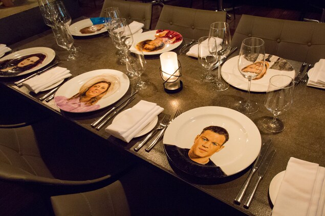 Une table est mise dans un restaurant et des visages sont peints sur les assiettes Une table est mise dans un restaurant et des visages sont peints sur les assiettes