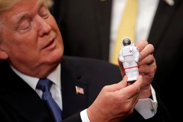 Le président Trump et une figurine d'un astronaute. Le président Trump et une figurine d'un astronaute.