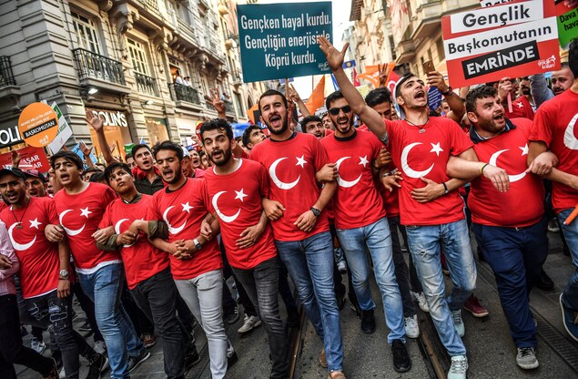 Des partisans du président Erdogan manifestent à Istanbul vêtus de t-shirts représentant le drapeau turc. Des partisans du président Erdogan manifestent à Istanbul vêtus de t-shirts représentant le drapeau turc.