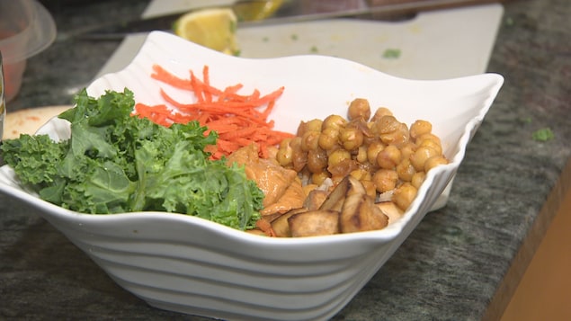 Un plat dans lequel on voit des carottes râpées, des pois chiches, du tofu ainsi que du chou frisé. Un plat dans lequel on voit des carottes râpées, des pois chiches, du tofu ainsi que du chou frisé.
