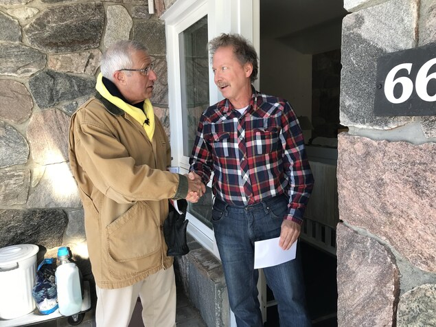 Victor Fedeli qui serre la main à un homme devant sa résidence. Victor Fedeli qui serre la main à un homme devant sa résidence.
