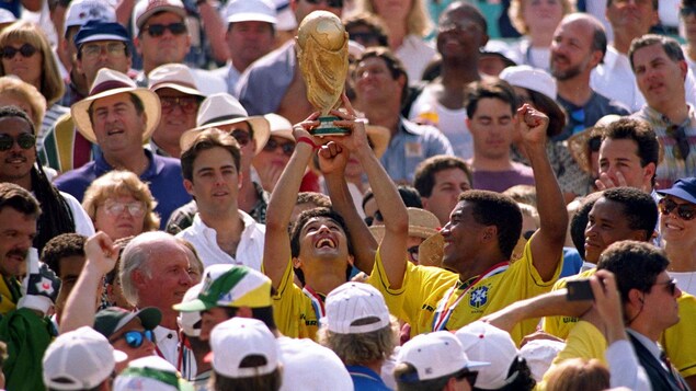 Il soulève la précieuse coupe du monde au milieu d'un groupe de partisans. Il soulève la précieuse coupe du monde au milieu d'un groupe de partisans.