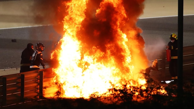 Des pompiers tentent d'éteindre un incendie sur une piste de course automobile.