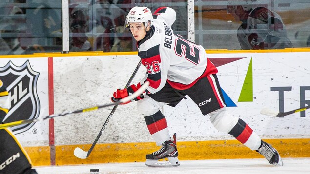 Un joueur de hockey transporte la rondelle alors qu'un adversaire s'approche de lui