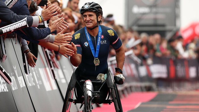 Alessandro Zanardi, souriant, serre des mains à l'arrivée d'une course en 2019.
