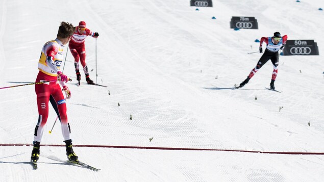 Johannes Klaebo regarde la bataille pour la 2e place entre Alex Harvey et Alexander Bolshunov dans la poursuite de 15 km à Québec.