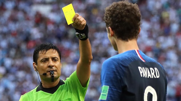 L'arbitre iranien Alireza Faghani donne un carton jaune à Benjamin Pavard de l'équipe de France. L'arbitre iranien Alireza Faghani donne un carton jaune à Benjamin Pavard de l'équipe de France.