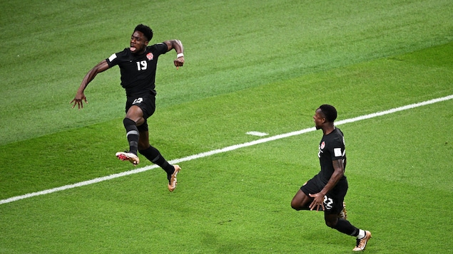 Deux joueurs de soccer célèbrent un but.