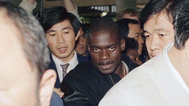 Ben Johnson se fraie un chemin à travers les journalistes à l'aéroport de Séoul le jour de son départ de la Corée du Sud, le 27 septembre 1988. Ben Johnson se fraie un chemin à travers les journalistes à l'aéroport de Séoul le jour de son départ de la Corée du Sud, le 27 septembre 1988.