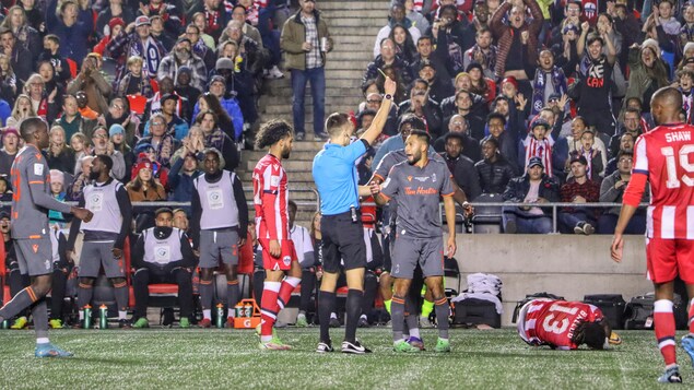 Un joueur de soccer se voit donner un carton jaune par un arbitre pendant un match.