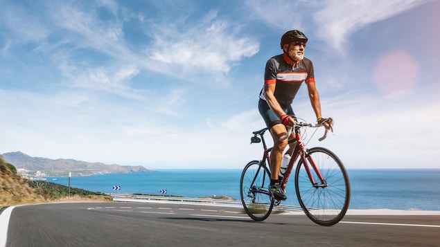 Un cycliste monte une côte à vélo.