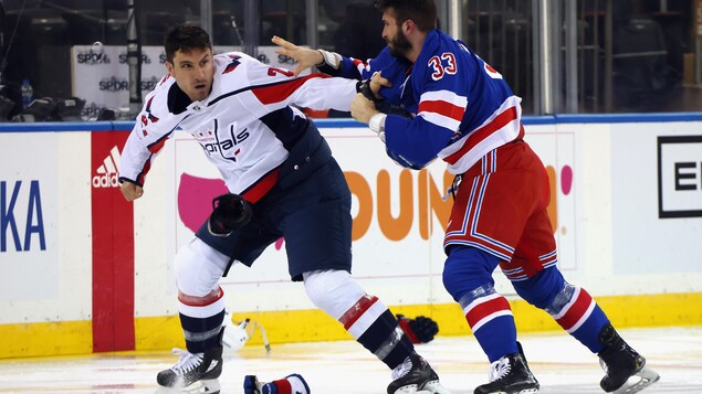 Deux joueurs se battent sur la glace.