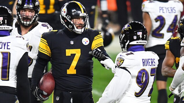 Le quart des Steelers tient le ballon dans sa main droite.