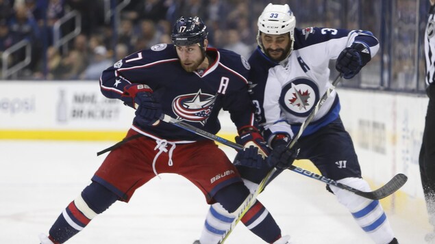 Deux joueurs de hockey près l'un de l'autre sur la glace.