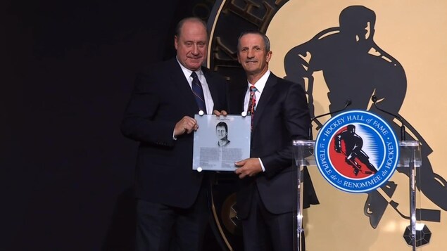 Bob Gainey remet une plaque commémorative du Temple de la renommée à Guy Carbonneau.