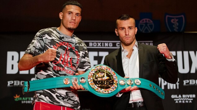 Deux boxeurs posent avec une ceinture de champion.