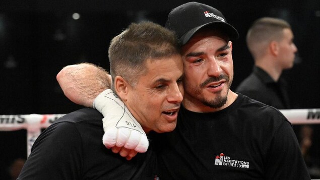Un boxeur donne une accolade à son entraîneur.