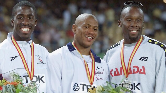 Trois coureurs posent fièrement avec leur médaille au cou.