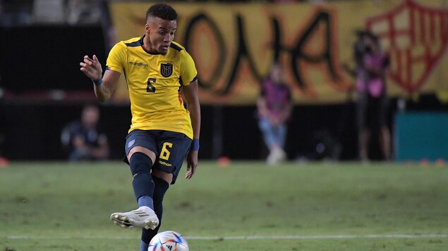Il fait une passe avec le ballon de soccer dans l'uniforme de l'Équateur.