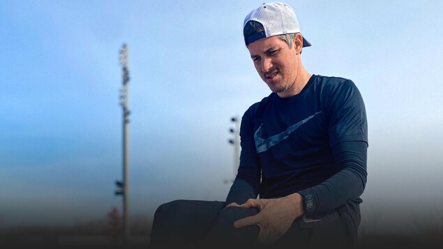 Photo d'un coureur assis, se tenant le genou.
