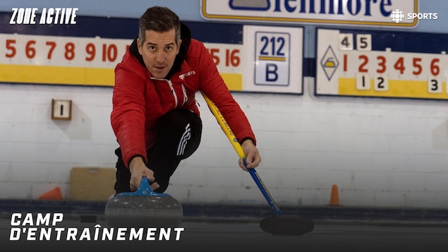 Un homme s'élance sur la glace en poussant une pierre de curling.