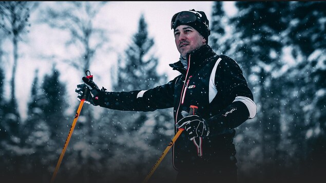 Photo d'un skieur de fond debout dans la forêt.