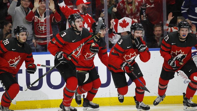 Les joueurs canadiens célèbrent un but.