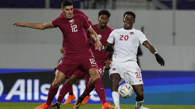 Jonathan David du Canada et Karim Boudiaf du Qatar se disputent le ballon.