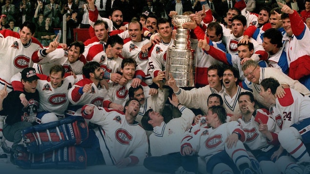 Un groupe de joueurs de hockey sourient et entourent la coupe Stanley.