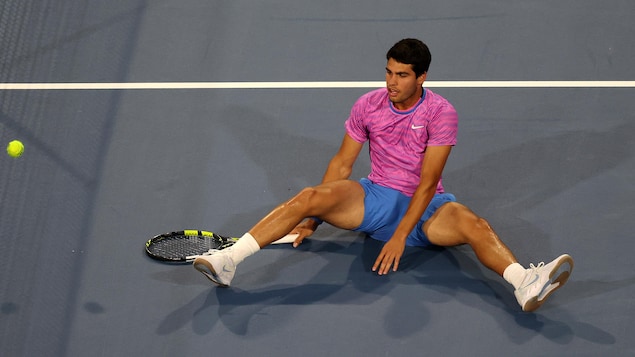 Le joueur de tennis Carlos Alcaraz est assis sur le court.