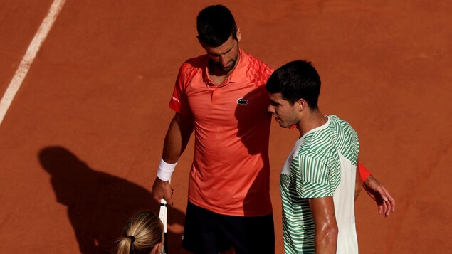 Deux joueurs de tennis sont près l'un de l'autre pendant une pause de jeu.