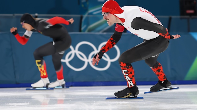 Deux patineurs s'affrontent lors d'une épreuve olympique. 