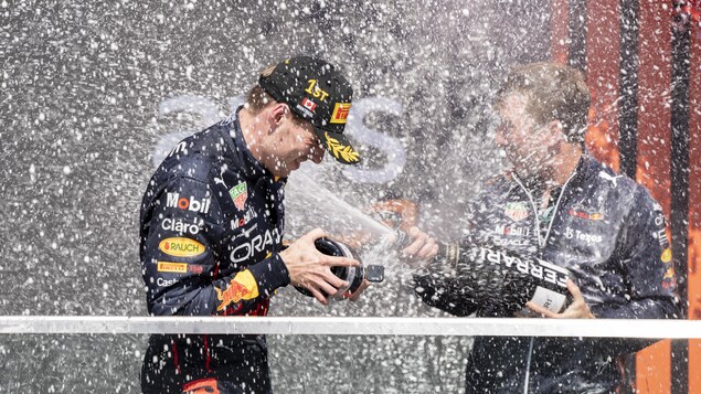 Max Verstappen se fait arroser avec un jet de champagne par un de ses co-équipiers.