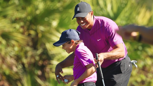Un père et son fils jouent au golf.