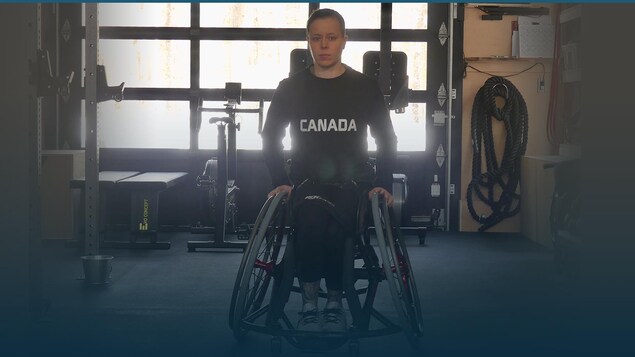Cindy Ouellet regarde la caméra, assise dans son fauteuil roulant.