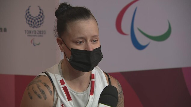 La joueuse de basketball en fauteuil roulant Cindy Ouellet portant un masque et répondant aux questions d'entrevue.