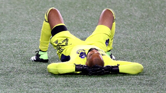 Le gardien est couché sur un terrain de soccer.