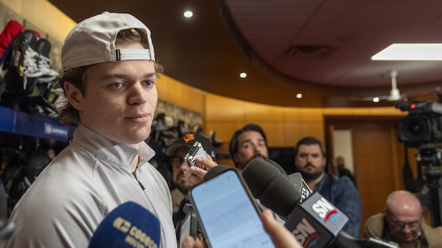 Il répond à des questions en mêlée de presse.