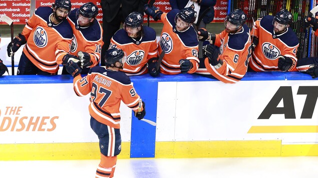 Connor McDavid reçoit les félicitations de ses coéquipiers au banc, après avoir inscrit un but.